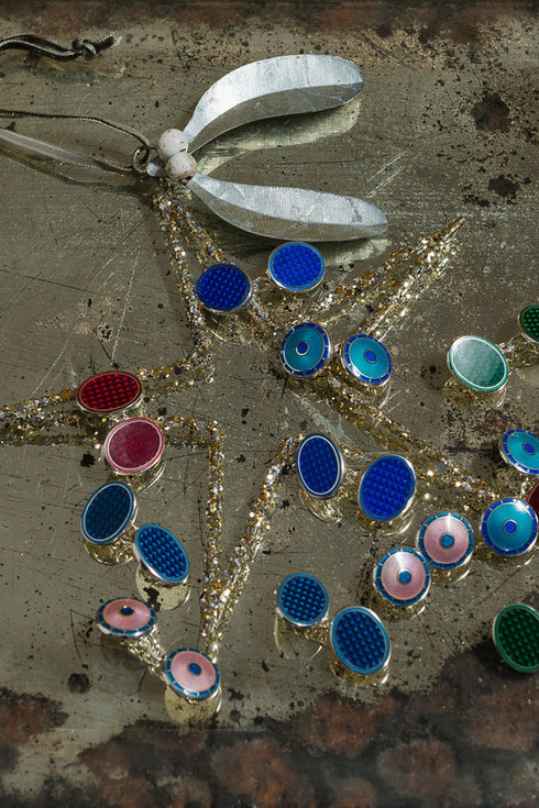 Close-up of decorative cufflinks with colorful gemstones on a textured surface