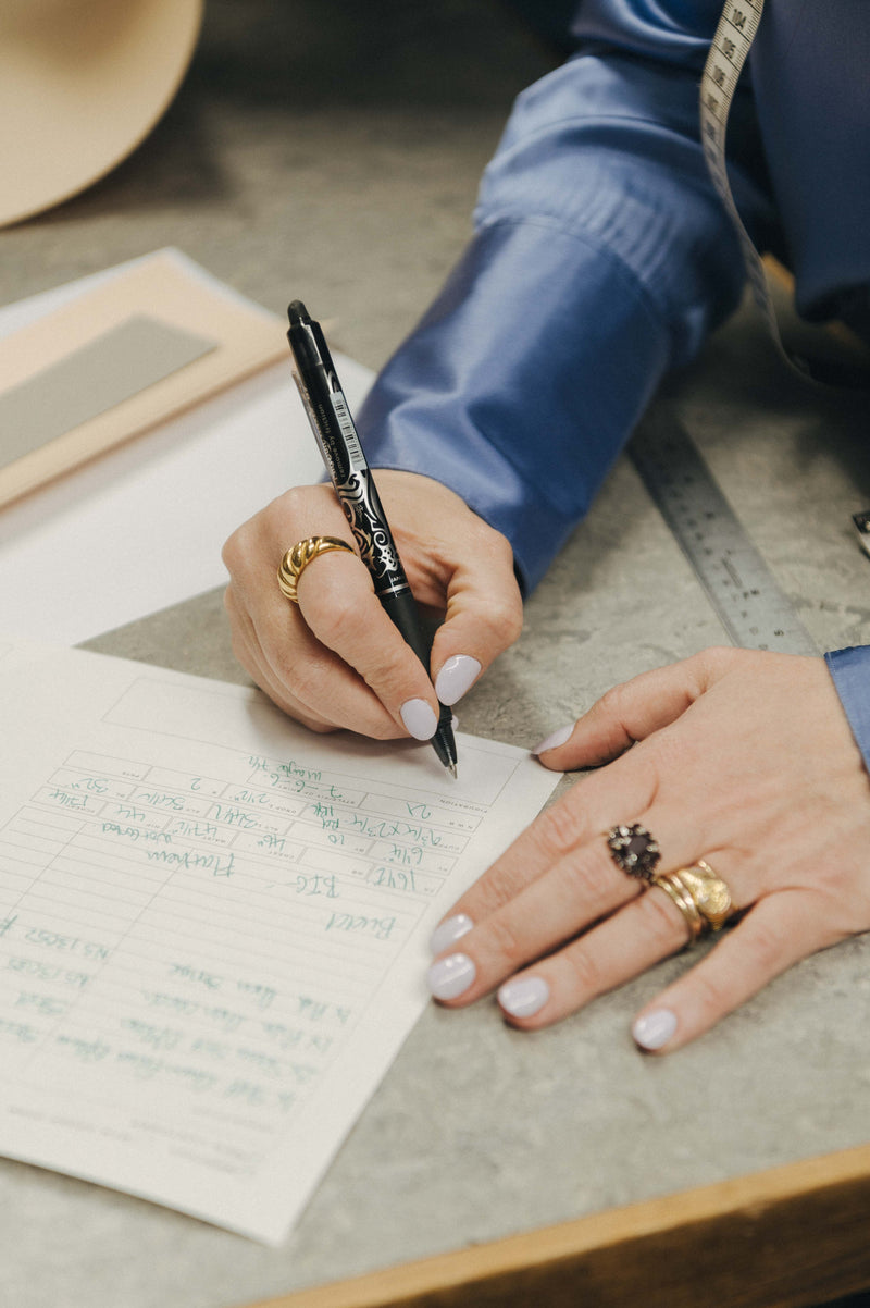 Bespoke cutter writing measurement for bespoke shirt order