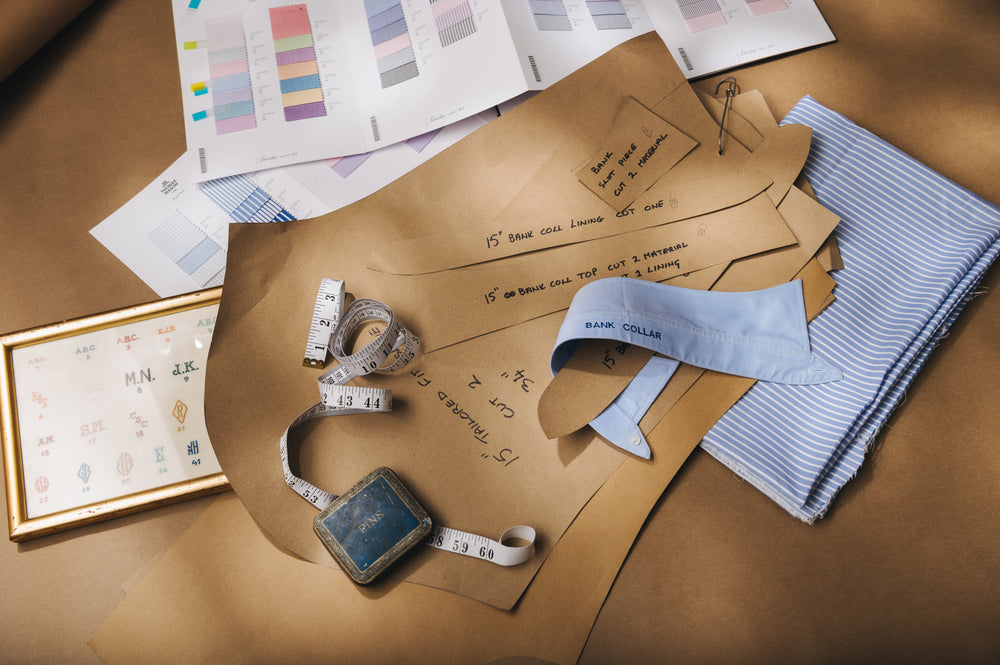 Fabric swatches, measuring tape, and design papers on a wooden surface