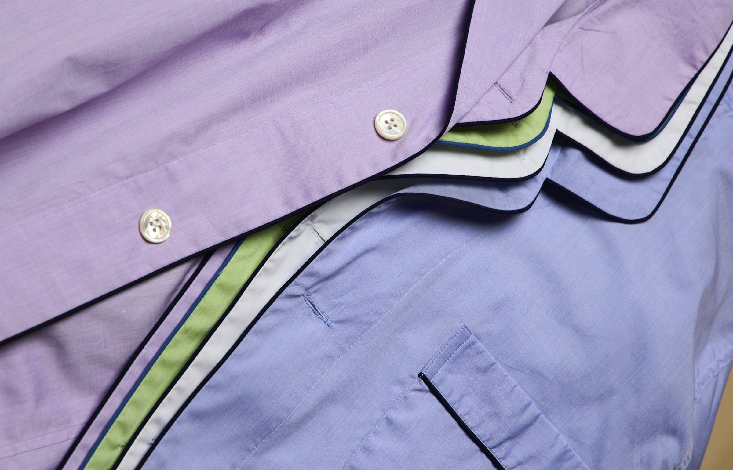 Close-up of a folded batiste pyjama shirts with a focus on the collar and buttons.
