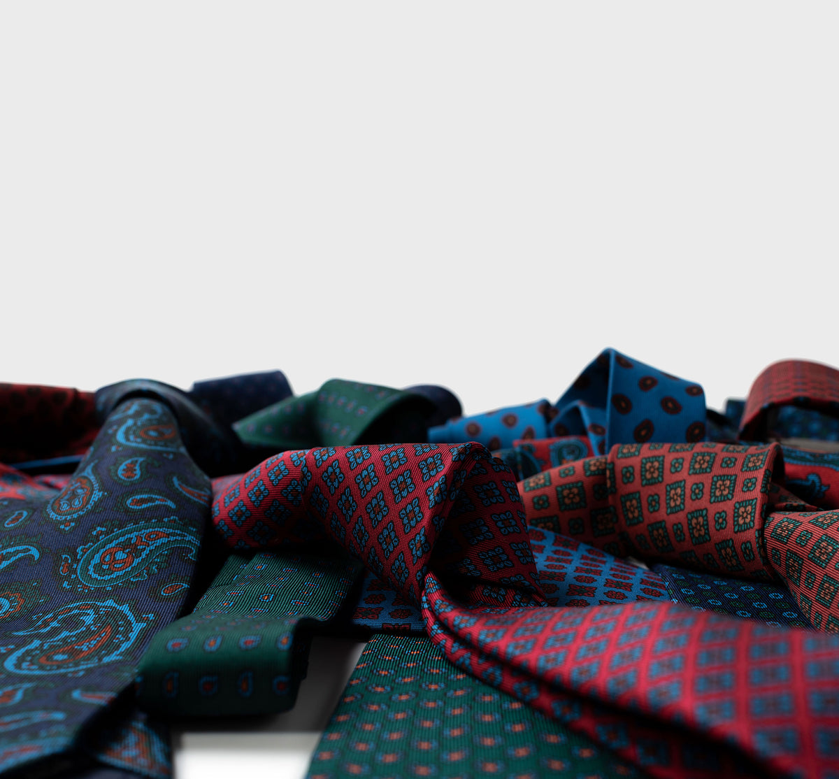 Collection of patterned ties in various colors on a light gray background