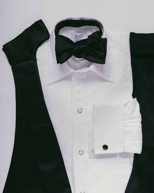 White dress shirt with black bow tie and sleeves on a light gray background