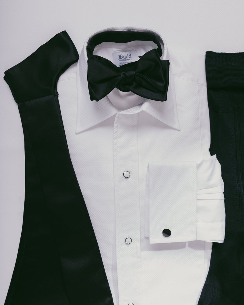White dress shirt with black bow tie and sleeves on a light gray background