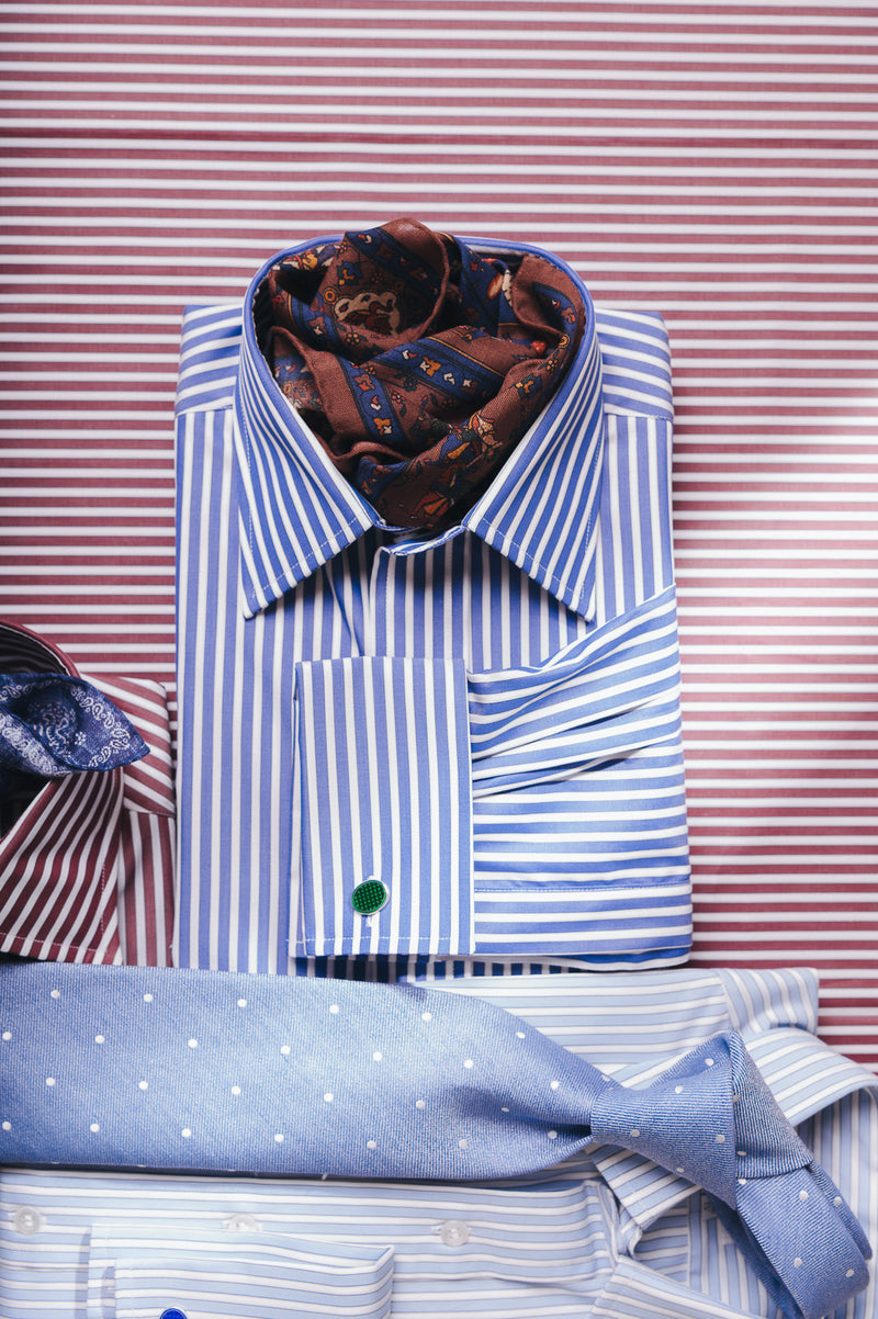 Striped blue shirts with tie and accessories on a burgundy stripe background