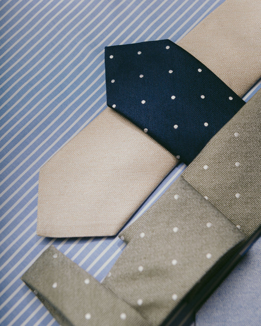 Ties laid overlapping on blue stripe background