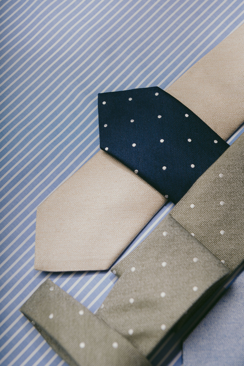 Three neckties with polka dot patterns on a striped background