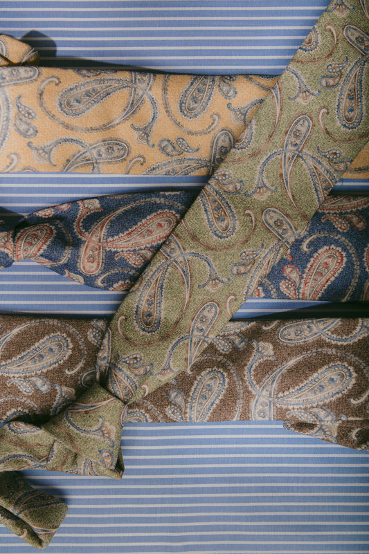 Three patterned ties on a striped background