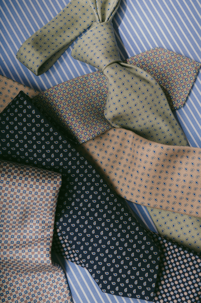 Collection of patterned ties on a striped fabric background