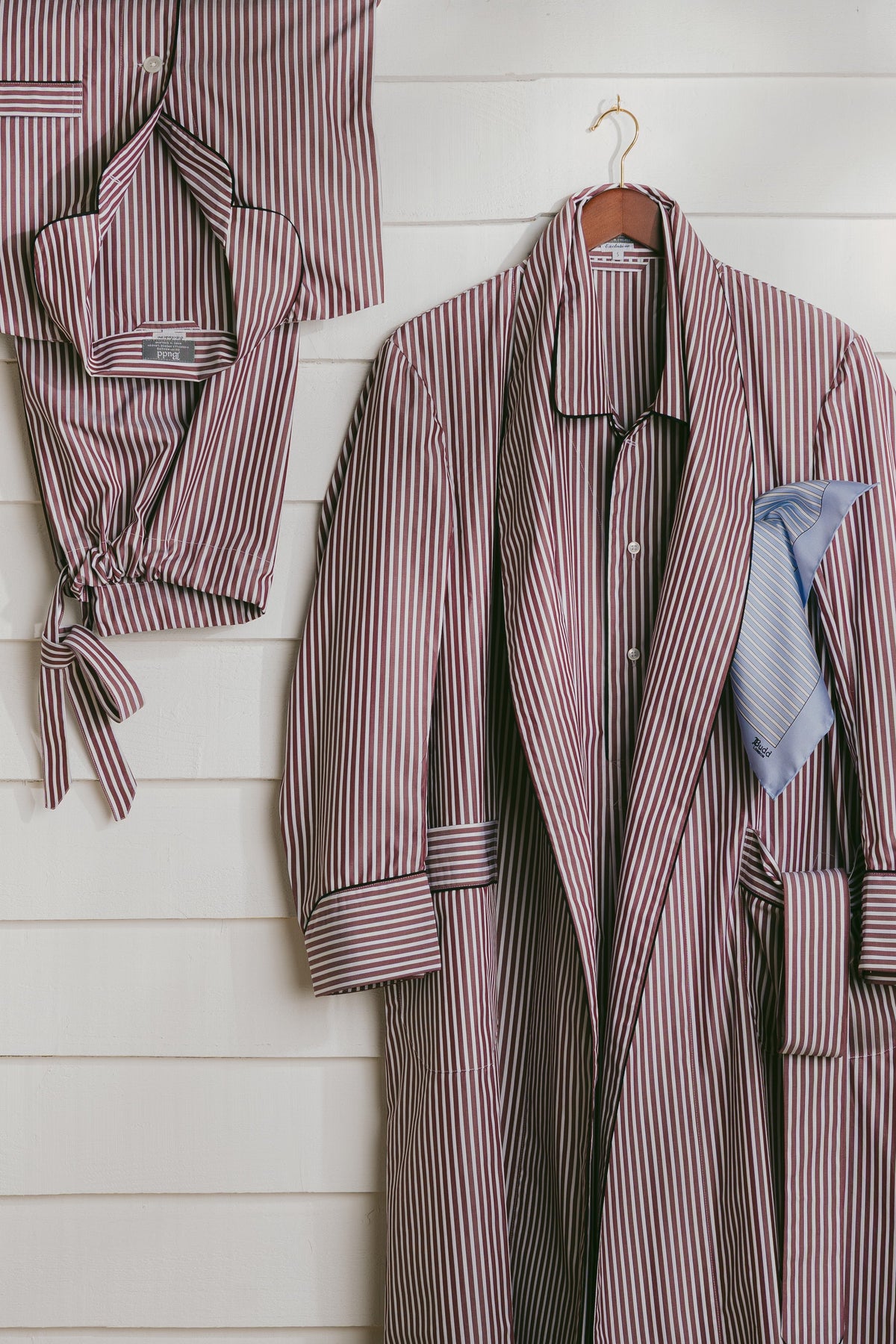 Burgundy stripe dressing gown and pyjamas against white wall