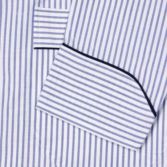 Close-up of a blue and white striped dressing gown sleeve  with navy piping trim.