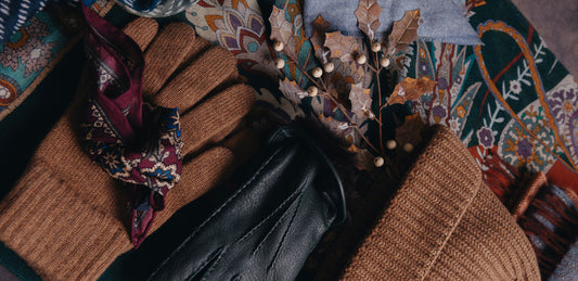 Pair of gloves and hat with a decorative pocket square on a textured surface