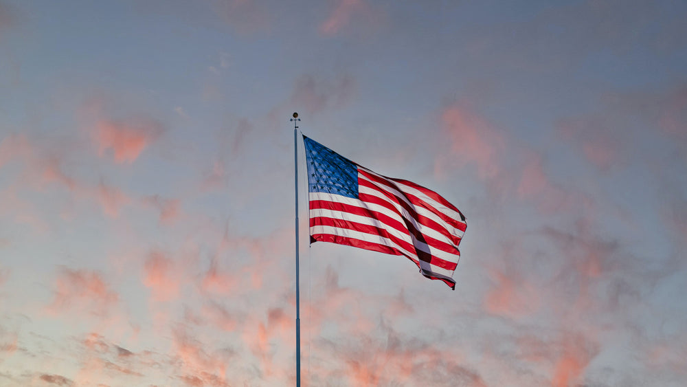 American flag flying in sunset sky